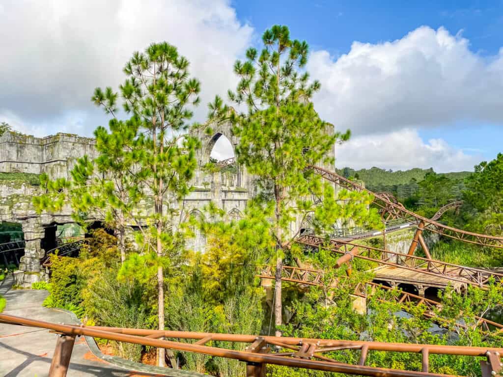 green trees in-between roller coaster track. This is part of the Hagrid's Motorbike adventure ride at Harry Potter World