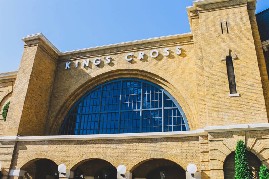 Yellow brick building with large semi-circular window. This is the replica of King's Cross Station in Harry Potter World Orlando