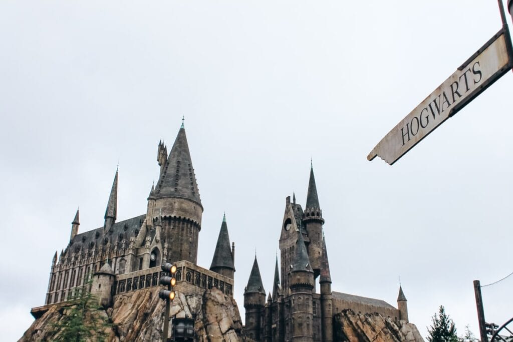 Hogwarts sign pointing to Hogwarts Castle in the distance at Harry Potter World in Islands of Adventure
