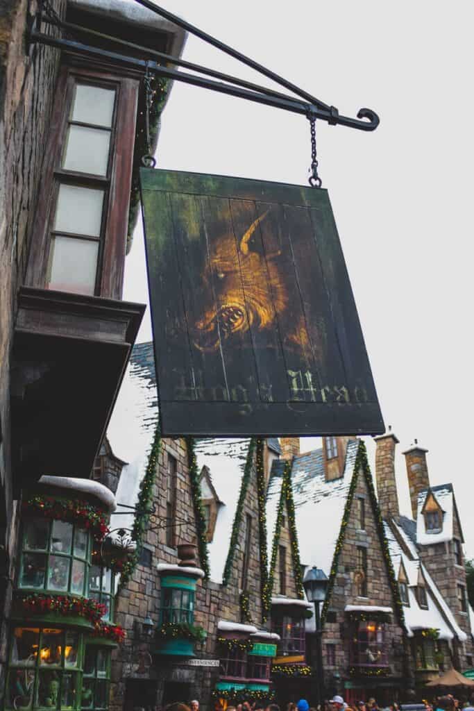 Hog's Head sign in front of Hogsmeade Village. Hog's Head is a bar at Harry Potter World