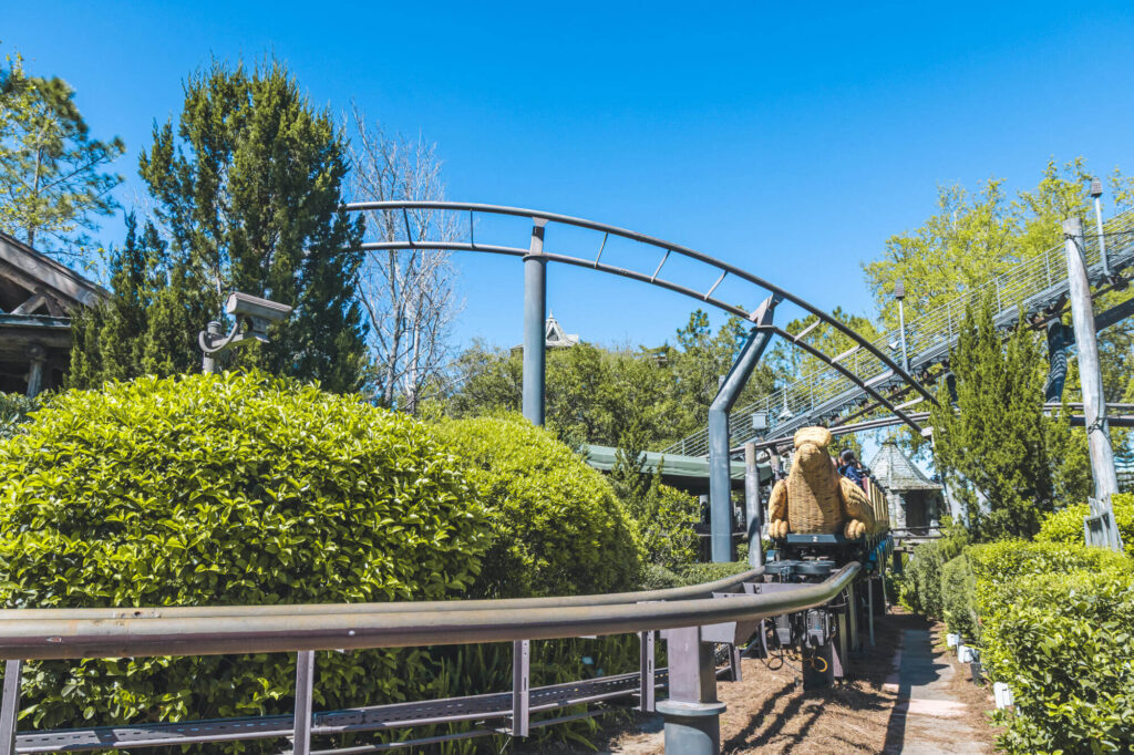Flight of the Hippogriff roller coaster in Hogsmeade, Islands of Adventure, surrounded by greenery and blue skies
