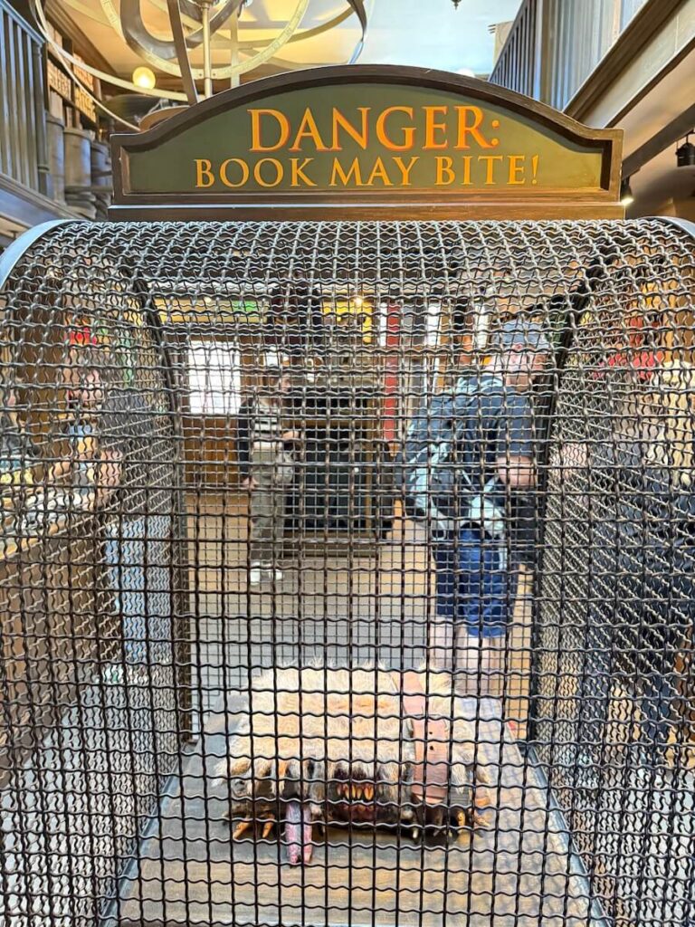 furry book inside of a cage with placard above that says "Danger! Book May Bite"