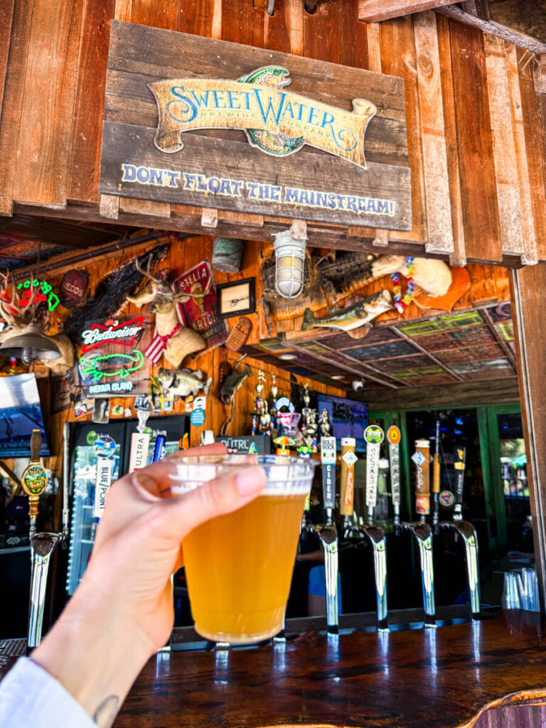 Draft beer held up at the bar at Wekiva Island, in front of a row of craft beer taps