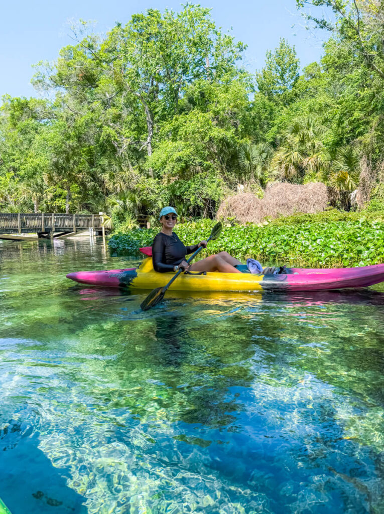 Woman in a pink and yellow kayak on crystal-clear water near the springhead just outside of Wekiwa Springs State Park