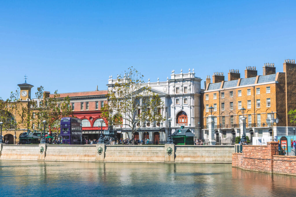 London waterfront area inside Universal Studios, Florida, with red, white, and brown building facades behind a lake and wall
